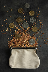 Wallet with penny and buckwheat lies on a gray background. The concept of poverty.