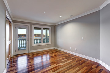 Empty room with hardwood floor and door to balcony.
