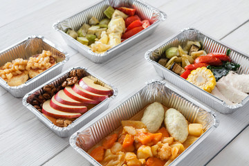 Healthy food take away in boxes, top view at wood