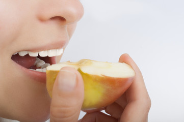 healthy teeth groomed girl biting an apple, isolated on white background, close-up