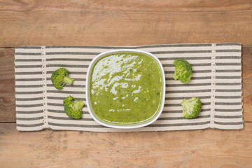 Tasty broccoli soup on a wooden background