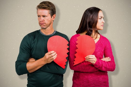 Composite image of serious couple holding cracked heart shape