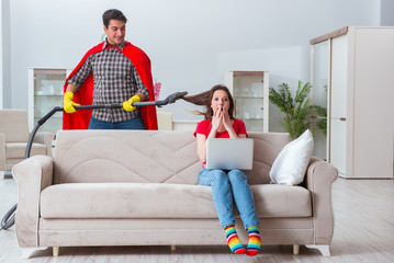 Obraz premium Superhero husband helping his wife at home