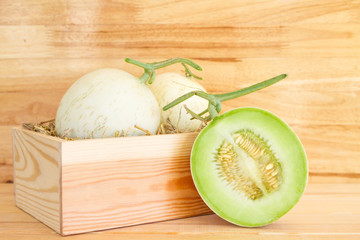 Green cantaloupe melon in wood box