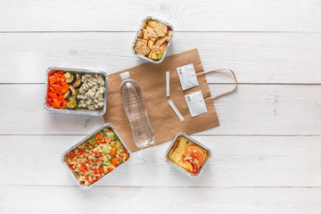 Healthy food take away in boxes, top view at wood