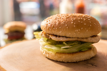 Burger on a wood board. Sesame bun and meat. Simplest recipe of a hamburger.