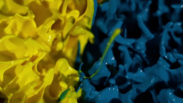 Blue and yellow paint mix on a thumping speaker in slow motion