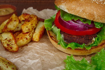 Big burger with fries on wooden