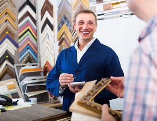 portrait of man seller taking order on picture frame from custom