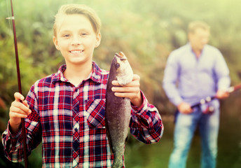 Fisher boy showing catch fish