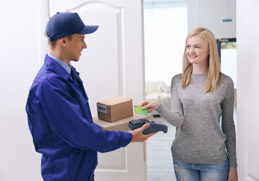 Young woman paying for package from courier