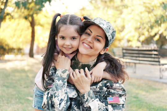 Woman in army uniform and her daughter in park