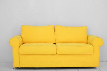 New cozy sofa on light wall background