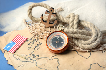 USA flag, rope and compass on old map. Columbus Day concept
