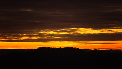 Fototapeta na wymiar Breathtaking sunset over mountain and silhouette landscape tree