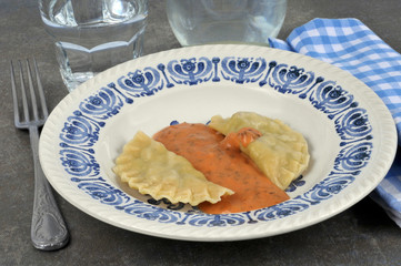 Assiette avec des ravioles et de la sauce