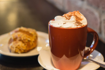 Coffe with whiped cream for breakfast with croissant in cafe