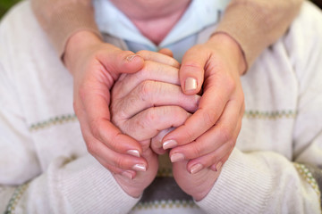 Elderly hands & young carer's hands