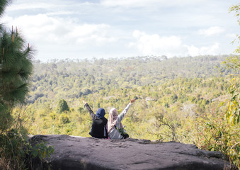 two muslim girl sit on rock