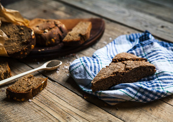 A loaf of fresh rustic wholemeal rye bread on a wooden board, rural food background.