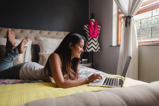 Teen Girl Using Laptop In Bedroom