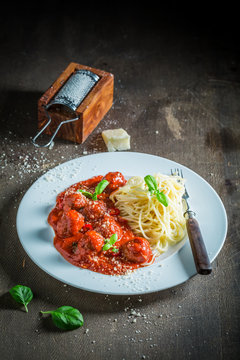 Delicious pasta bolognese with meatballs and parmesan