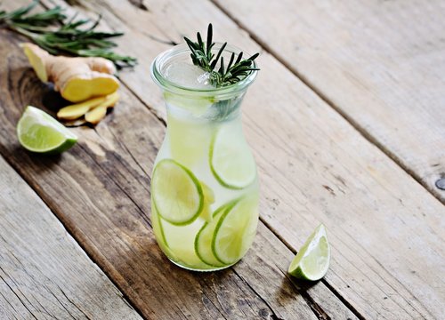 Infused water with lime,ginger and rosemary.Cold refreshing detox summer drink .Selective focus