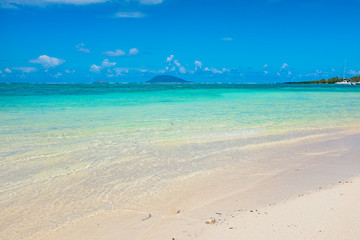 Beach on the tropical island. Clear blue water, sand and palm tr