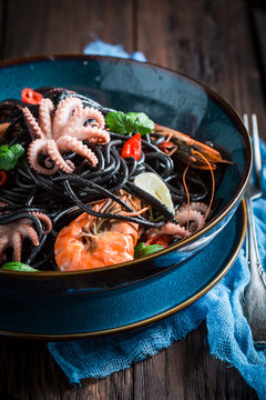 Spicy seafood black pasta with shrimp, octopus and parsley