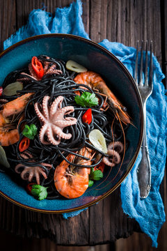 Fresh seafood black pasta with shrimp, octopus and parsley