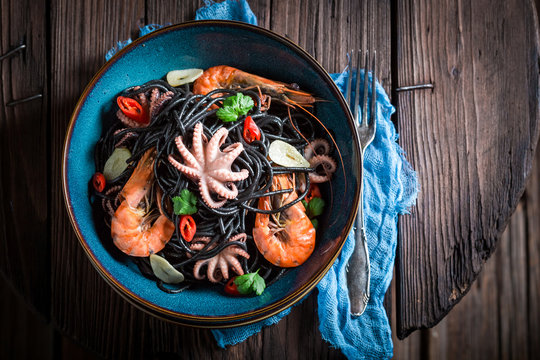 Enjoy your seafood black pasta with shrimp, octopus and parsley