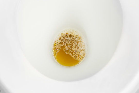 Urine or pee and bubble in white flush bowl toilet in restroom