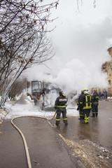 Obraz premium fire brigade extinguish a burning car