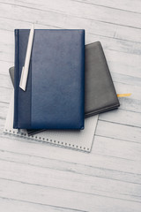 notebooks on the table and a white ball pen