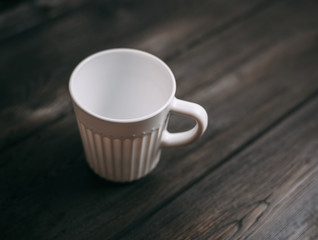 white mug on a wooden background, top view