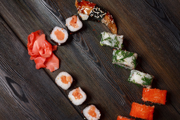 sushi and rolls on a wooden background, ginger