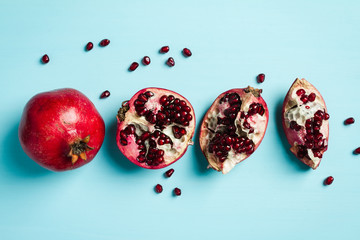 Whole and cut pomegranates on blue background