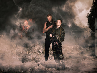 Obraz premium girl and man in military camouflage uniforms among the ruins