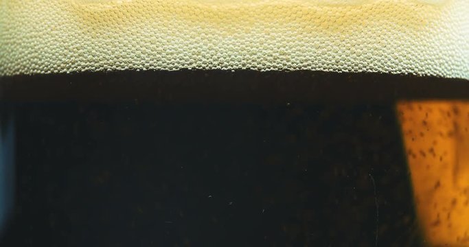 Glass full of beer slow moving bubbles 4K