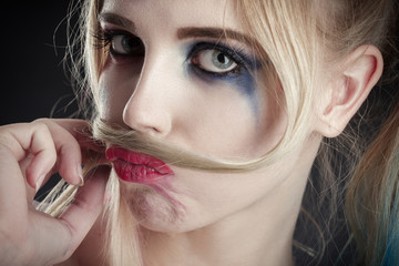 fun blond girl making fake mustache from her hair