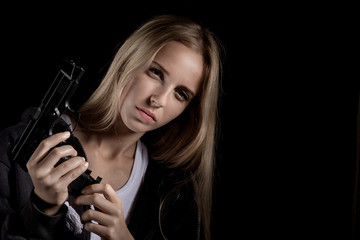 serious girl with gun on black background with copyspace