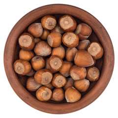 Hazelnuts in a brown plate. Isolated on white background.