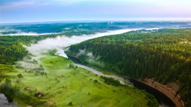 Fields and pine forest landscape at summer. Aerial view of misty foggy forest and the sunset at the evening time. Filmed on drone cinema camera. Ecology and nature forest concept.