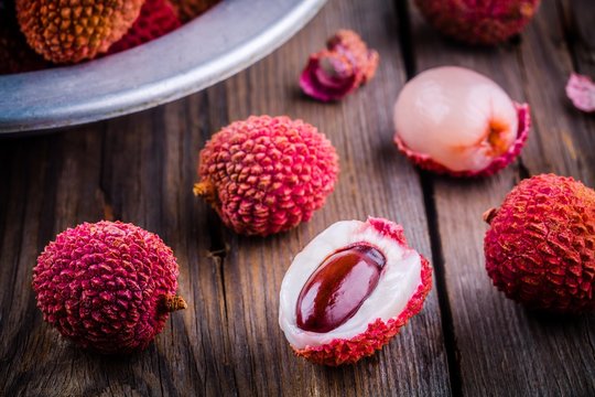 Fresh organic lychee fruit in a bowl on wooden background