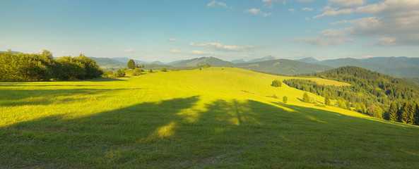 Panoramic view of a meadow with a small chapel and mountains  in Slovakia