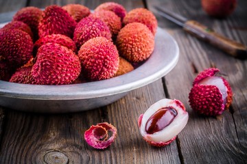 Fresh organic lychee fruit in a bowl on wooden background