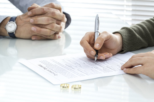 Wife signs divorce decree form with ring