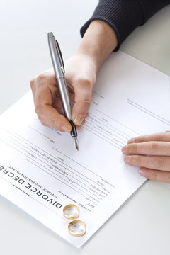 Wife signs divorce decree form with ring