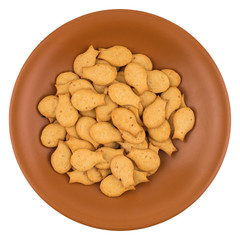 Goldfish Crackers in brown plate. Isolated on white background.