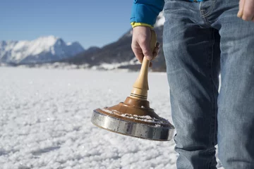 Foto op Plexiglas Hand mit Eisstock vor winterlicher Gebirgslandschaft © groisboeck